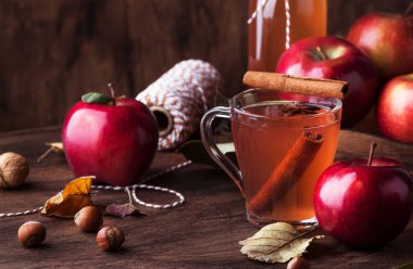 Ahşap zemin üzerinde tarçın çubukları, karanfil ve anason bulunan sıcak elma şarabı. Geleneksel sonbahar, kış içkileri ve kokteyller