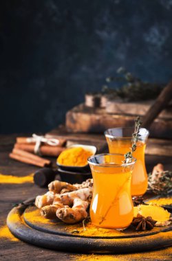 Tahta tepside cam bardakta bal bulunan sağlıklı vegan zerdeçal altın çayı. Şifalı baharatlı çay. 