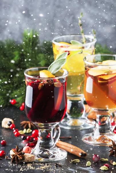 Mulled wine and mulled cider. Hot winter drinks and cocktails for christmas or new year\'s eve in glass mugs with spices and citrus fruit