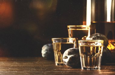 Slivovica - erik brendisi veya erik votkası, sert likör, eski ahşap masadaki bardaklarda sert içki, taze erikler, fotokopi alanı - klasik ses tonlu