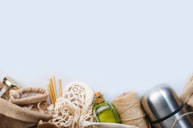 Sıfır atık, plastiksiz ve sürdürülebilir yaşam tarzı konsepti. Geri dönüşümlü, yeniden kullanılabilir çevre dostu çantalar, paket, şişe, kutu ve konteynırlar, ağ torbası. Gri arkaplan, kopyalama alanı, üst görünüm