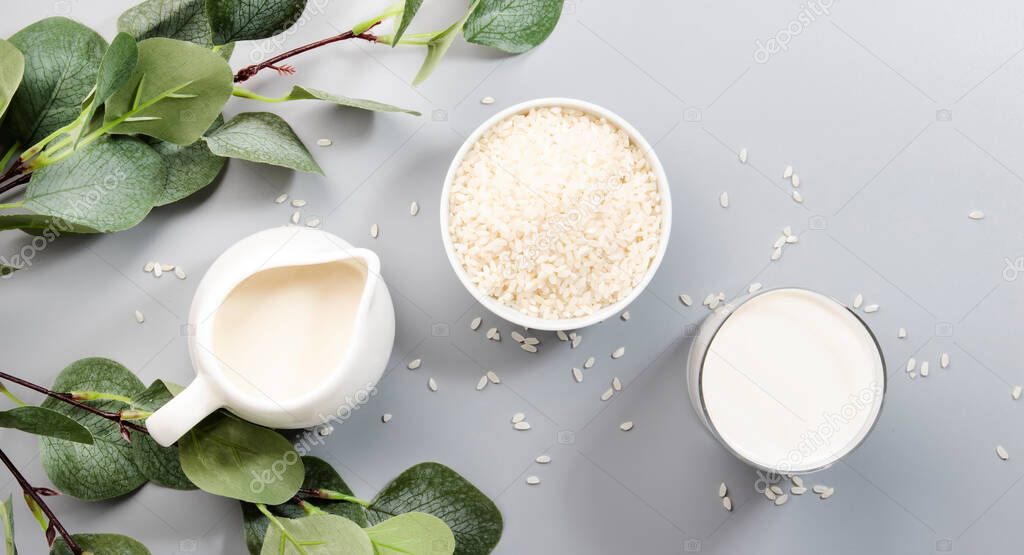 Vegan Rice milk with rice grains on gray background. Copy space, top view