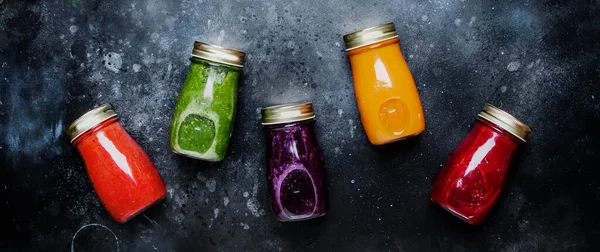 Food and drinks, healthy and useful multicolored vegetable juices and smoothies with ingredients in glass bottles. Panoramic banner with copy space