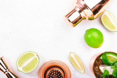 Nane şurubu ya da Moskova katır kokteyli. Bakır bardakta limon, zencefilli bira, votka ve nane. Beyaz tablo, üst görünüm, kopyalama alanı