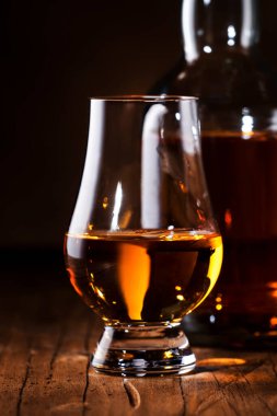 Buzsuz viski bardaklarda ve şişelerde, kırsal ahşap arka planda, kopyalama alanı