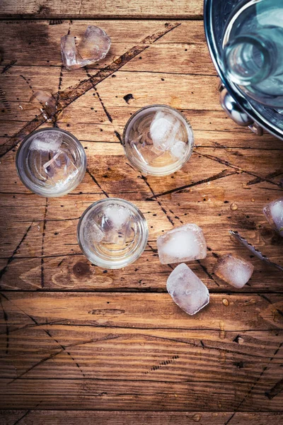 Wodka Borrelglaasjes Houten Achtergrond Ijskoude Sterke Drank Misvormd Glas Bovenaanzicht — Stockfoto