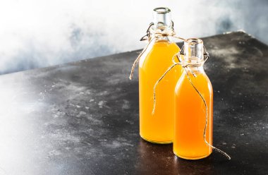 Ev yapımı mayalanmış Raw Kombuha. İçmeye hazır çay. Boşluğu Kopyalayan Gri Mutfak Masası Arkaplanı