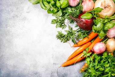 Taze kök sebzeleri ve baharatlı bitkiler. Sağlıklı yemek, yaz aşçılığı konsepti. Kopyalama alanı olan gri bir arkaplan. Üst görünüm