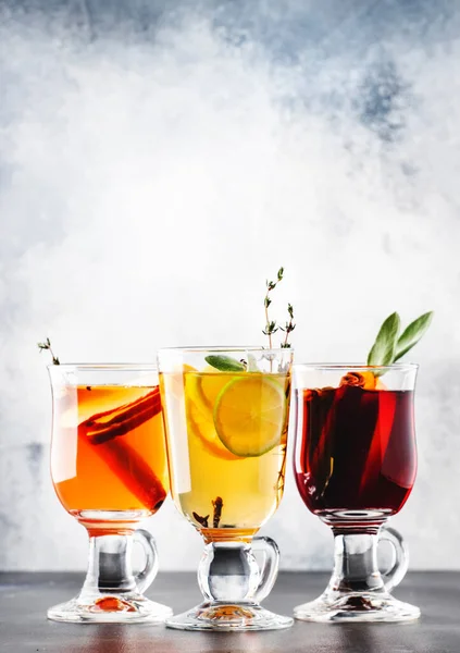 Kırmızı ve beyaz şaraptan sıcak şarap ve sıcak elma şarabı. Sonbahar ya da kış içecekleri ve cam bardaklarda baharatlar ve narenciye meyveleriyle kokteyller.