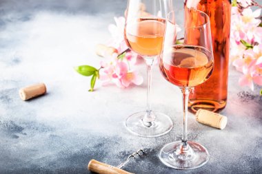 Gri masalı ve pembe çiçekli gül şarabı kadehi. Rosado, rosato ya da şarap tadımı, bar konsepti. Boşluğu Kopyala