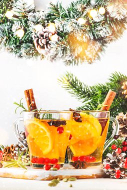 Noel 'de ya da yeni yıl sofrasında yabanmersini, limon ve baharatlı sıcak çay, beyaz arka plan ve kar