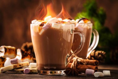 Sıcak kakao ya da cam bardaklarda krema ve ahşap masada kış süsü olan çikolatalı içecekler. Rahat Noel ve yeni yıl tatili kavramı, kopyalama alanı