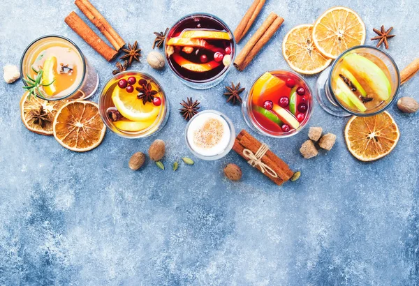 Çeşitli sonbahar veya kış mevsimsel alkol sıcak kokteylleri - sıcak şarap, glogg, grog, eggnog, sıcak zencefilli gazoz, sıcak tereyağlı rom, punç, gri arka planda sıcak elma şarabı, fotokopi alanının üst görüntüsü