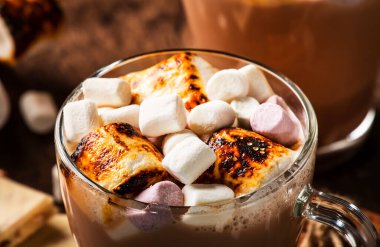 Sıcak çikolata ya da cam bardakta krema ve ahşap masada kış süsü. Rahat Noel ve yeni yıl tatili kavramı, kopyalama alanı