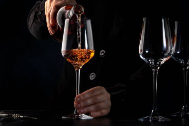 Şarap tadımında şarap barına, bara ya da restorana gül şarabı koyan şarap garsonu. Koyu arkaplan