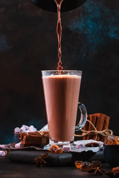 将冬季热巧克力可可饮料倒入黑色桌子上的高杯中 深蓝色背景 复制空间 — 图库照片