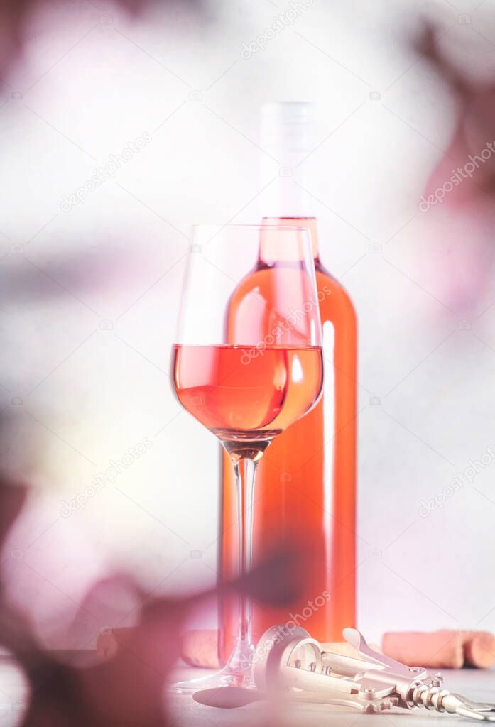 Rose wine glass with bottle on the gray table. Pink rosado, rosato or blush wine tasting in wineshop, bar concept. Copy Space