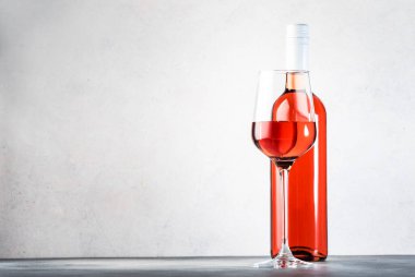 Gri masadaki kırmızı şarap kadehi. Pembe rosado, rosato ya da şarap tadımı, bar konsepti. Boşluğu Kopyala