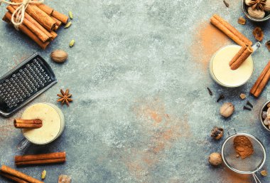 Eggnog sıcak kışı ya da sonbahar kokteyl içecekleri sütlü, yumurtalı ve koyu romlu, tarçın ve hindistan cevizi serpiştirilmiş gri arka planda cam bardaklar, Noel masası seti, üst manzara