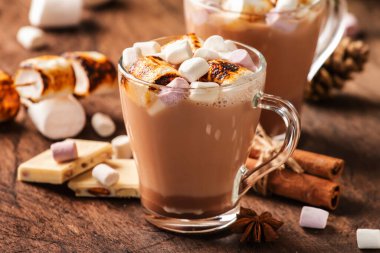 Sıcak çikolata ya da cam bardakta krema ve ahşap masada kış süsü. Rahat Noel ve yeni yıl tatili kavramı, kopyalama alanı