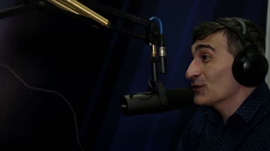 Bir Dj adam bir radyo istasyonu bir mikrofona konuşur yakın çekim.