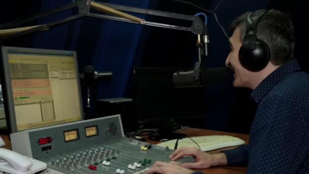 Bir radyo istasyonu bir erkek spiker bir mikrofona konuşur.. — Stok video