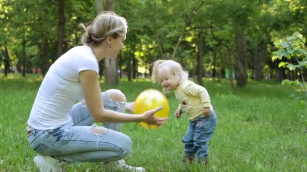 Een vrouw speelt met een kind in het park. — Stockvideo