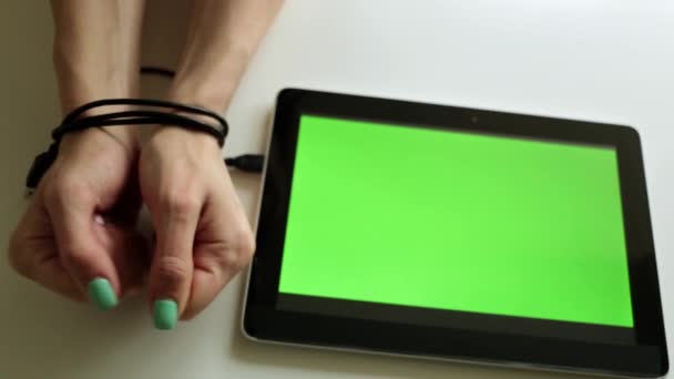 Το χέρι είναι συνδεδεμένη με ένα tablet με μια πράσινη οθόνη. — Αρχείο Βίντεο