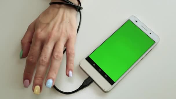Dependencia del smartphone. La mano está atada al teléfono con una pantalla verde . — Vídeos de Stock