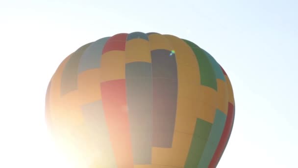 Luchtballon vliegt tegen de achtergrond van de zonnestralen. — Stockvideo