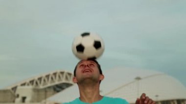 Bir futbol topu ile bir top stadyumun arka planı olan bir adam.
