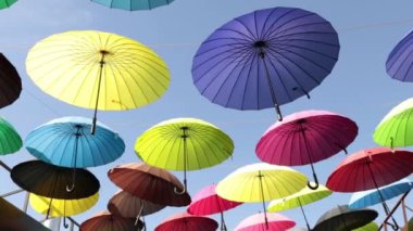 Bir şehir sokak üzerinde Güneş'ten çok renkli şemsiyeler.
