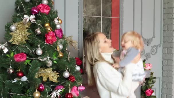 Een vrouw met een kind is het hebben van pret in de buurt van de kerstboom. Vakantie Nieuwjaar en Kerstmis. — Stockvideo