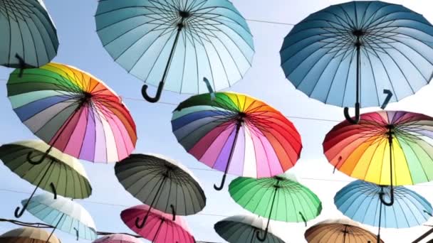 Πολύχρωμες ομπρέλες ενάντια στον ουρανό. Οδός χρωματιστές ομπρέλες. — Αρχείο Βίντεο