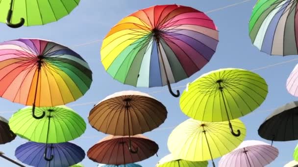 Muchos paraguas brillantes contra el cielo. Calle de sombrillas de colores . — Vídeo de stock