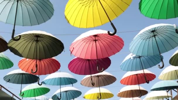 Straat van gekleurde paraplu's. Veelkleurige parasols tegen de hemel. — Stockvideo