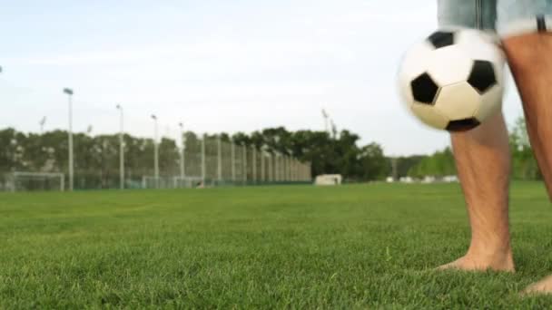 Un homme joue avec un ballon de football sur l'herbe . — Video