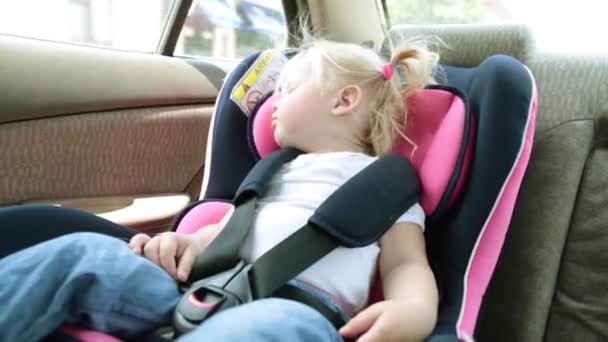 Barn reser i bilen. Ett litet barn sover i en bilbarnstol. — Stockvideo
