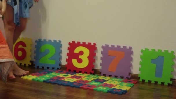 Un petit enfant apprend à marcher. L'enfant fait les premiers pas . — Video