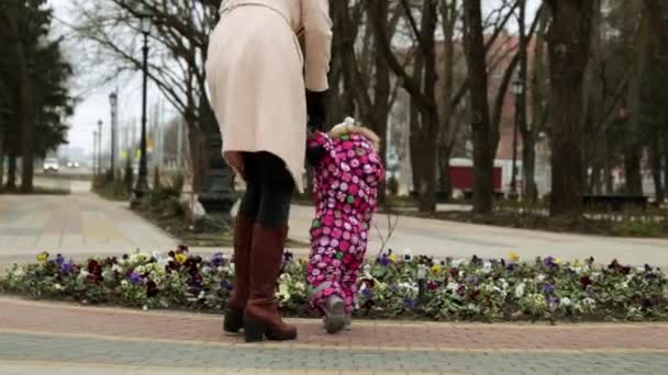 Una donna cammina con un bambino in un parco autunnale . — Video Stock