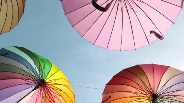 Mångfärgade paraplyer mot himlen, närbild. — Stockvideo