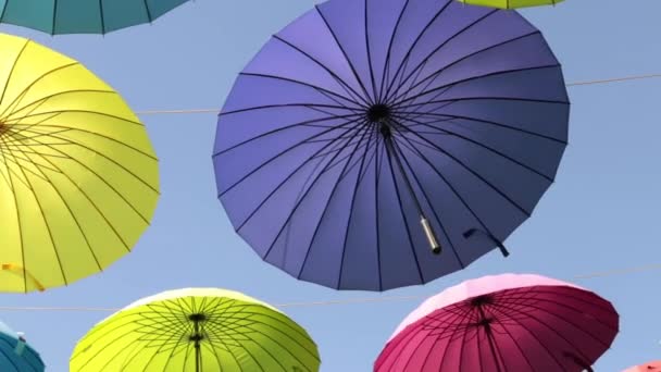 Straat van gekleurde paraplu's. Veelkleurige parasols stijgen in de hemel. — Stockvideo