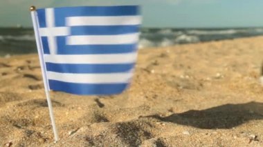 Sandy beach, futbol topu ve Yunanistan bayrağı.