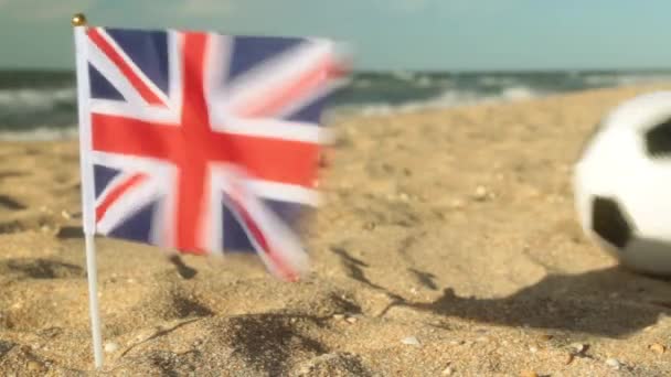 Sandy beach, futbol topu ve Büyük Britanya bayrağı. — Stok video