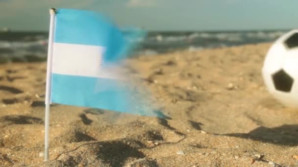 Spiaggia di sabbia, palla da calcio e la bandiera di Argentina . — Video Stock