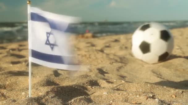 Sandy beach, fotbalový míč a vlajka Izrael. — Stock video