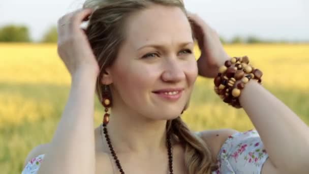 Retrato de una hermosa mujer sobre un fondo de campo de trigo . — Vídeo de stock