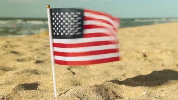 ビーチで米国の旗。砂浜のビーチでアメリカの国旗. — ストック動画