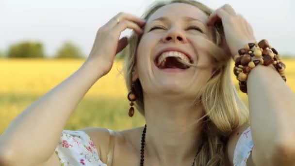 Portret van een mooie jonge vrouw lachen op de achtergrond van de natuur. — Stockvideo
