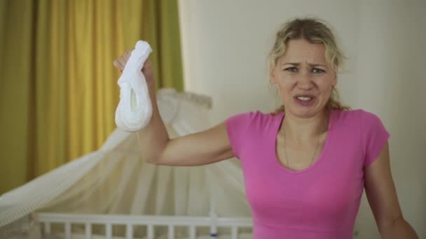 女性は、赤ちゃんの汚れたおむつを保持しています。経験の浅い、若い母親. — ストック動画
